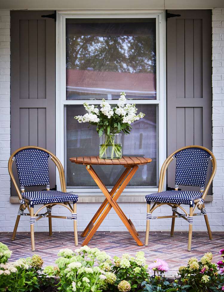 Coffee table and blue chairs with colorful interlock paving. Credit to Better Homes & Gardens