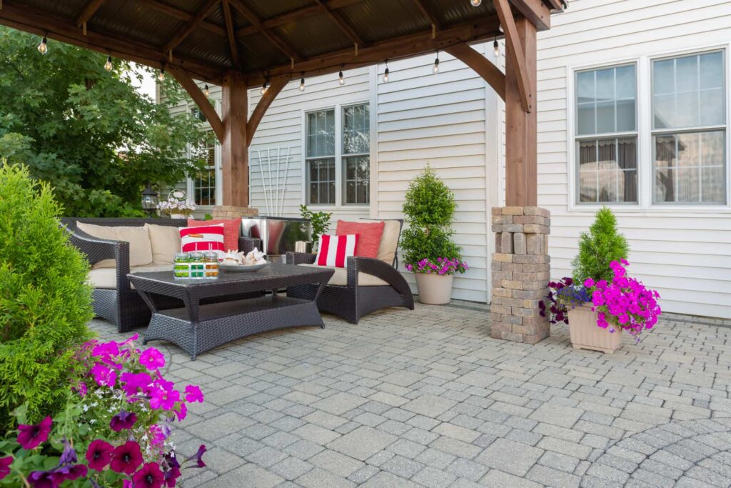 Un patio arrière avec gazebo sur un pavé uni sur mesure. Aménagement paysager.