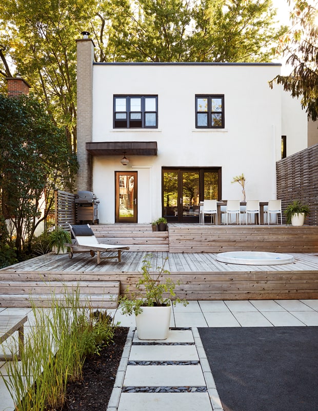 Wooden patio and paving stones backyard. Credit to House & Home.