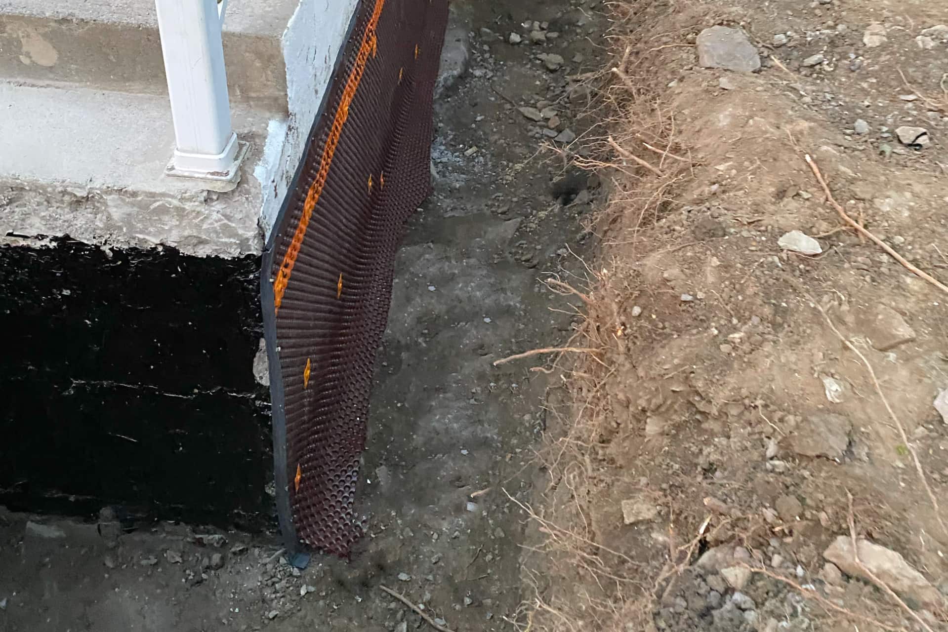 Foundation repair in Montreal with Delta membrane installation and waterproof coating on exposed concrete wall.