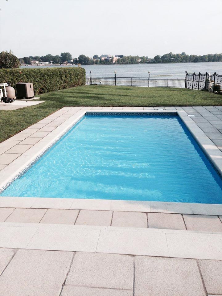 Luxurious swimming pool near St-Lawrence river in Montreal, by Large stone paved driveway in front of a luxury home in Montreal done by L'Entreprise Générale Paysagiste Riccardi